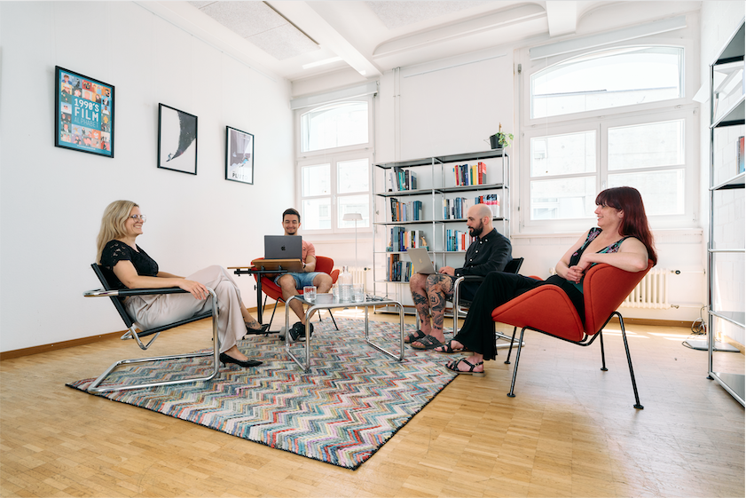Ein Sitzungszimmer mit Bücherregalen und vier Sesseln