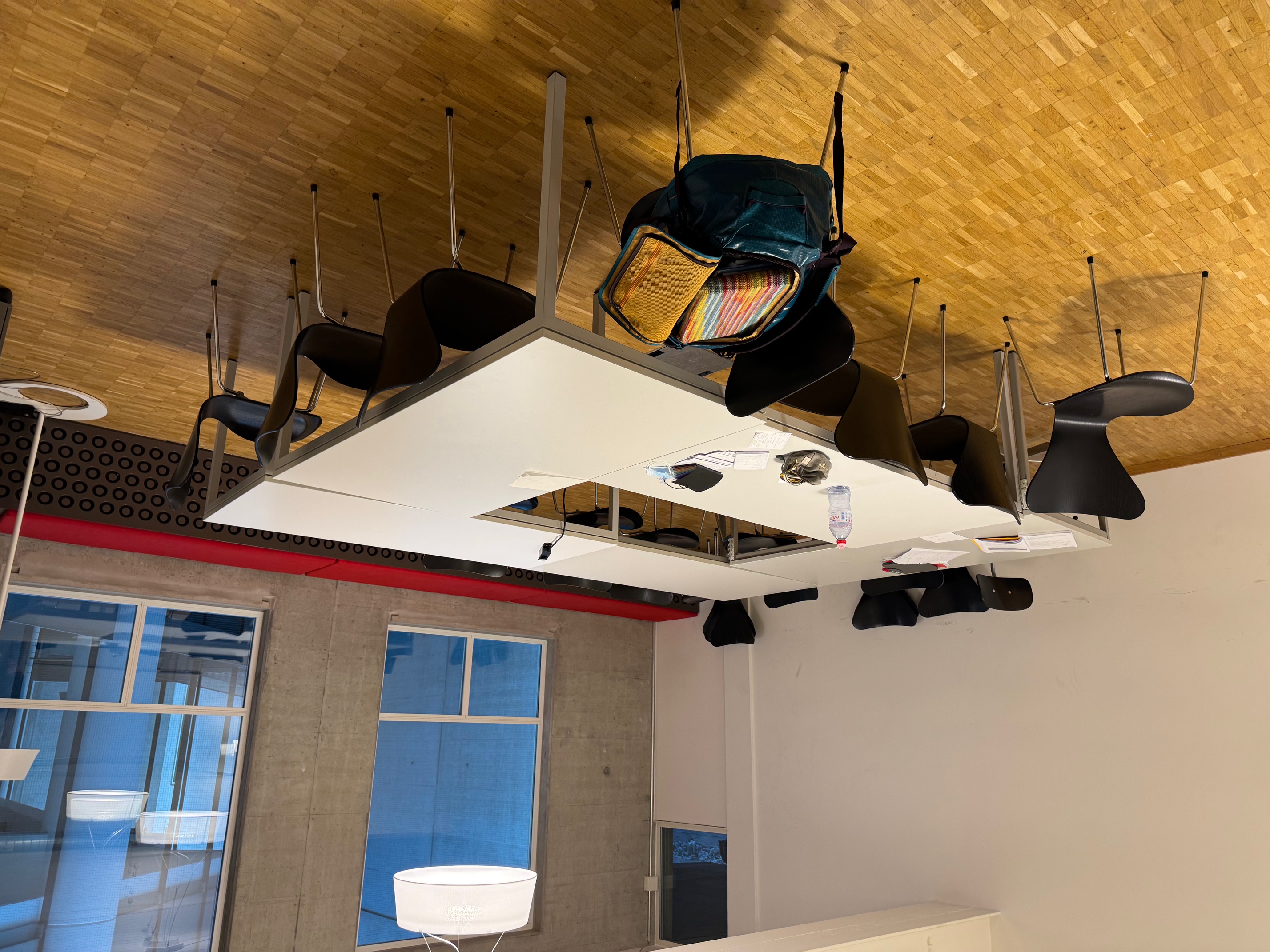 Ein Sitzungszimmer mit vier Tischen im Quadrat und einer gepolsterten Bank
